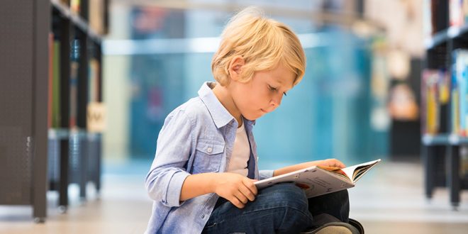 Adorable Little Boy Sitting In Library