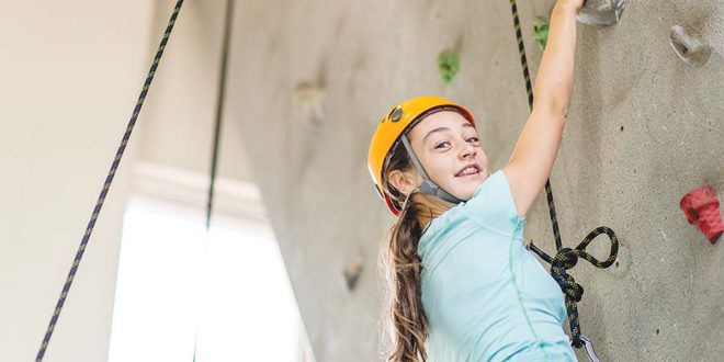 Teenage girl indoor rock climbing