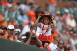 Little girl in Orioles merch in the crowd at a game 