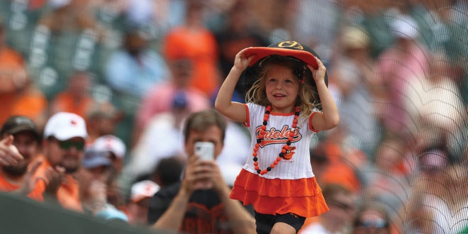 Little girl in Orioles merch in the crowd at a game