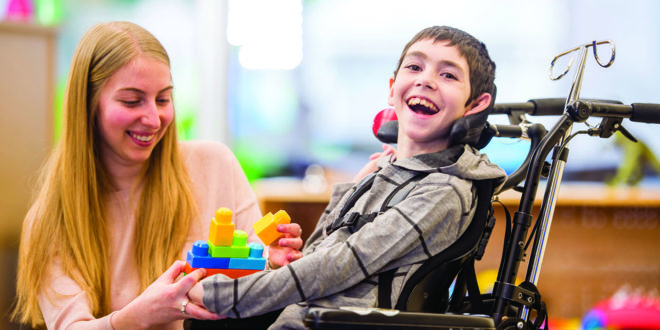 A child with a disability plays with toys and has a good time.