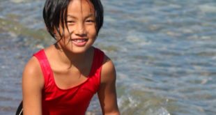 A young person enjoys the ocean.