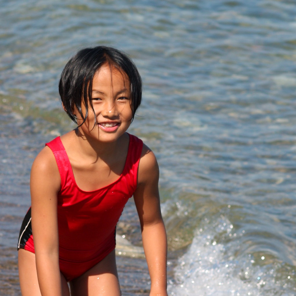 A young person enjoys the ocean.