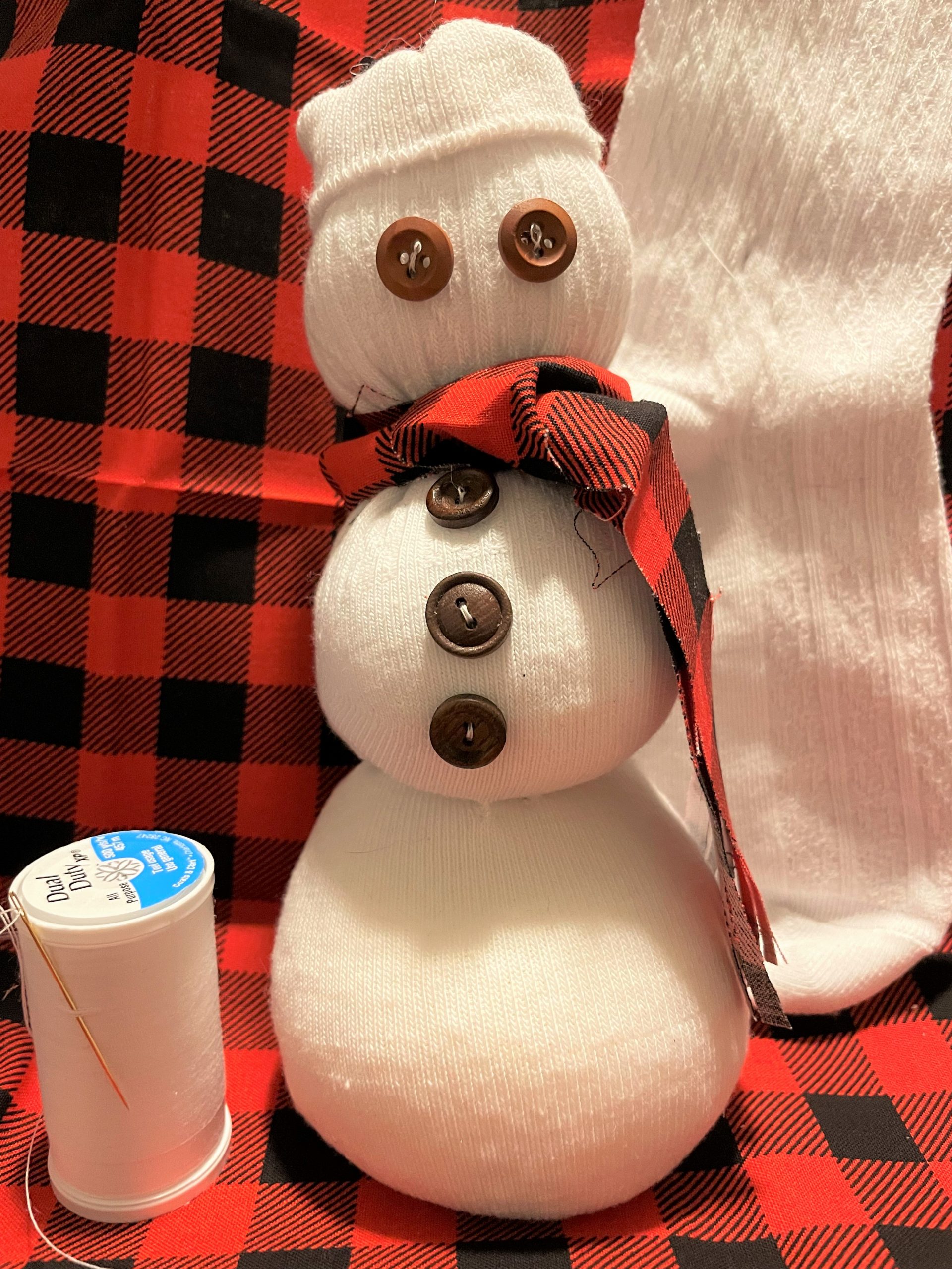 A snowman made from a sock. It has little button eyes. How cute!