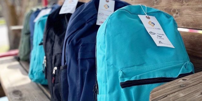 Blue backpacks filled with supplies for children in foster care.