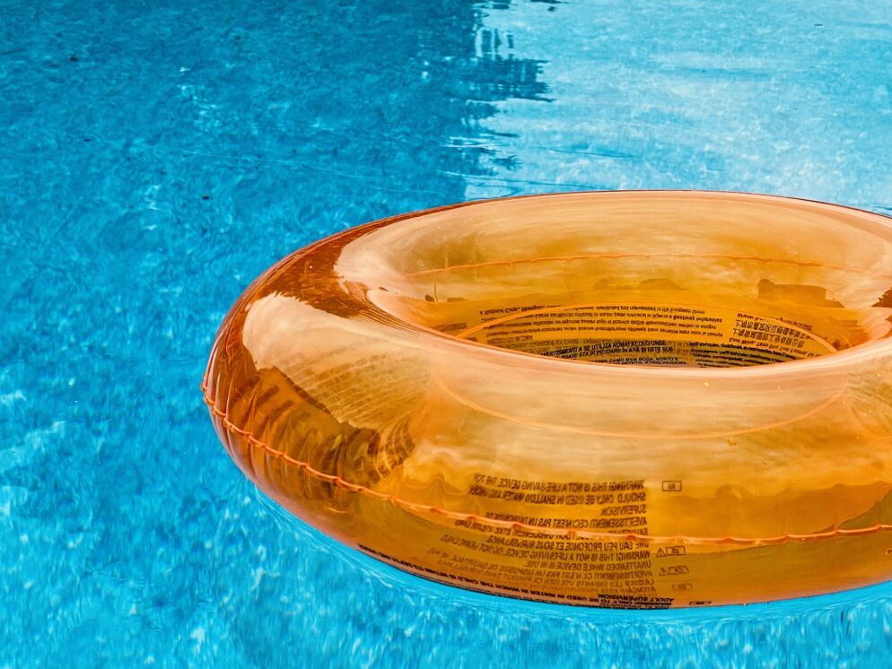 An orange floatie drifts in a pool.