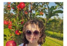A little girl holding an apple