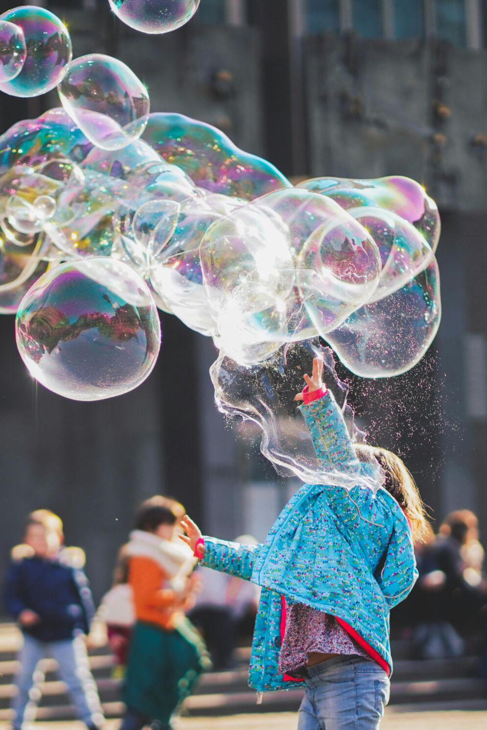 Girl making large bubbles with a bubble wand