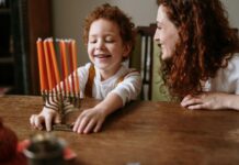 A boy and his mom celebrate Chanukah with a menorah