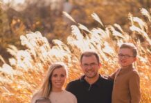 A family of four sitting in a field