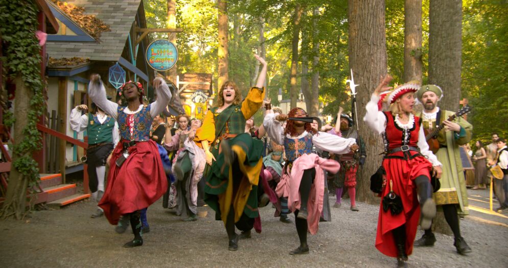 People dressed in costumes at a renaissance faire dancing