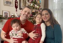 A family sitting in front of a Christmas tree