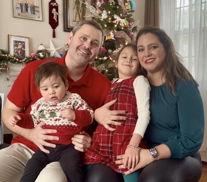 A family sitting in front of a Christmas tree