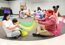 A parent and child playing with silk scarves