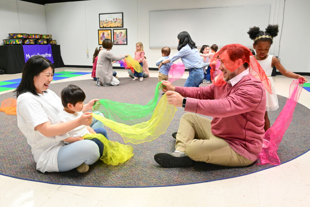 A parent and child playing with silk scarves
