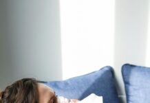 Child laying on a couch blowing nose