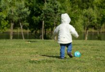 Boy kicking soccer ball alone