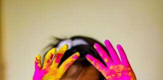 A child shows off his hands covered in colored powder after a Holi celebration