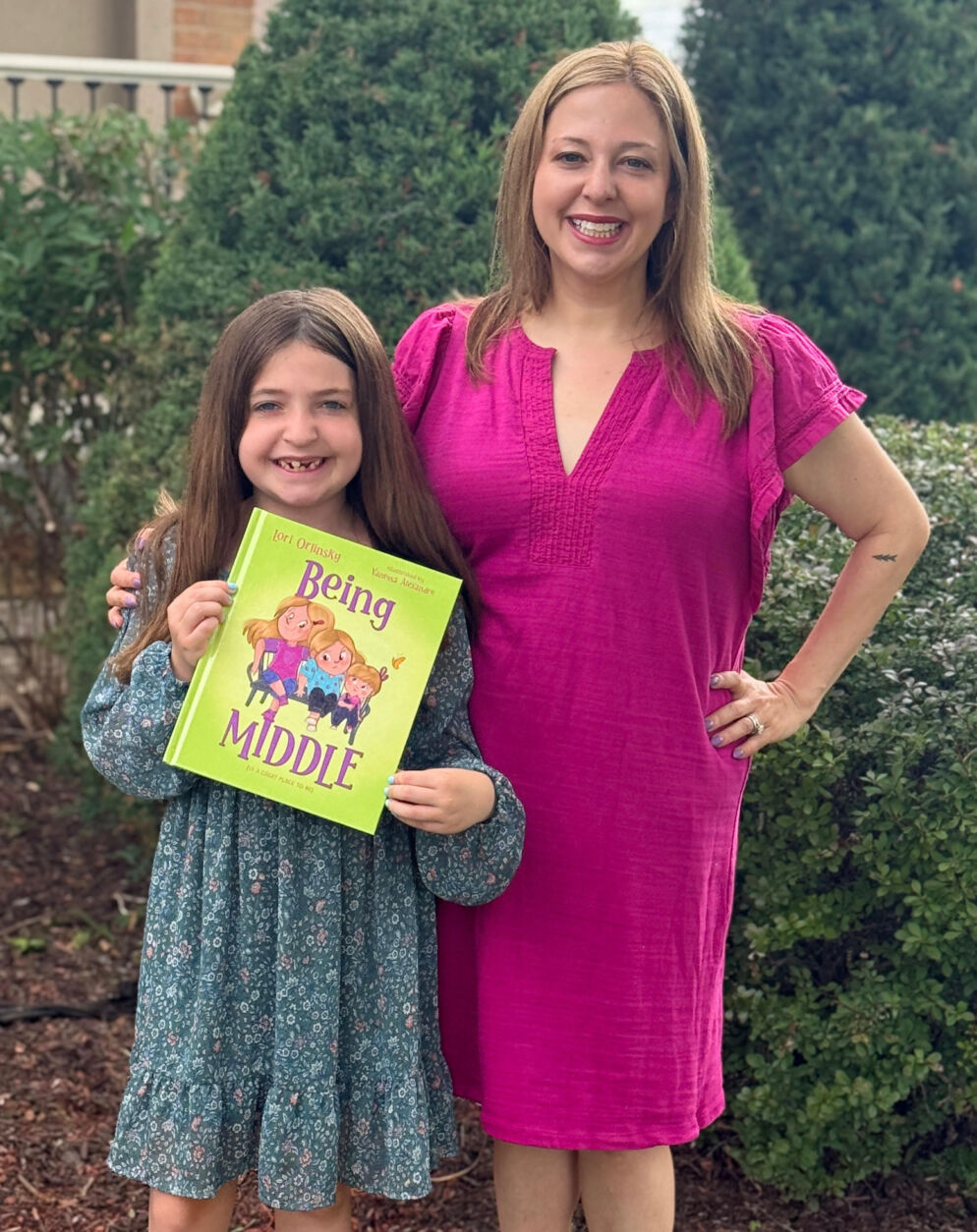 A girl holding a book and her mother