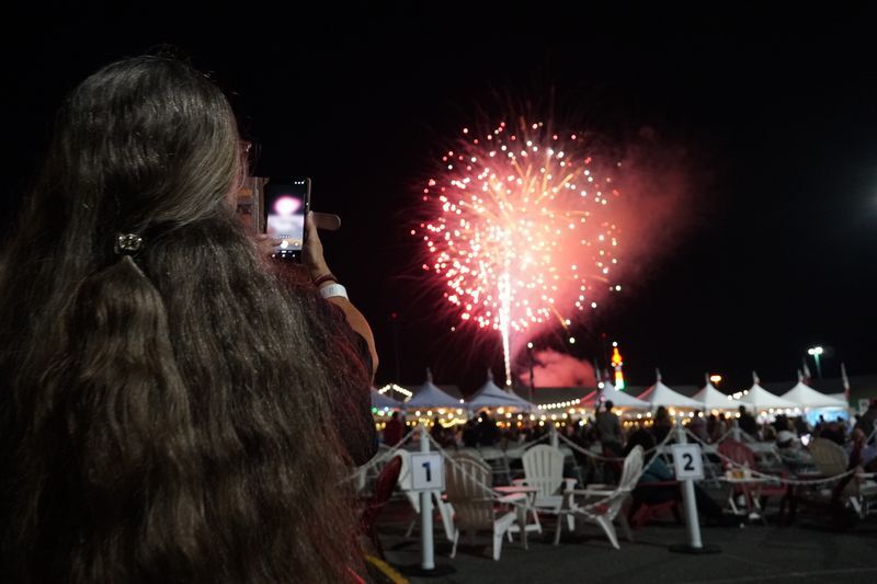 A woman records fireworks on her phone