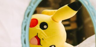 A Pikachu plushie looking in a mirror