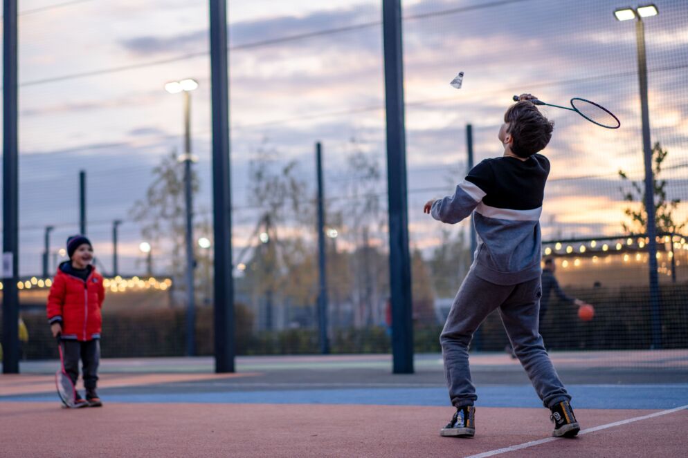 Two kids playing badminton