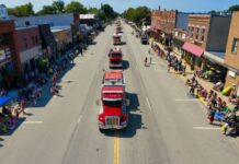 Trucks going down a street during a parade
