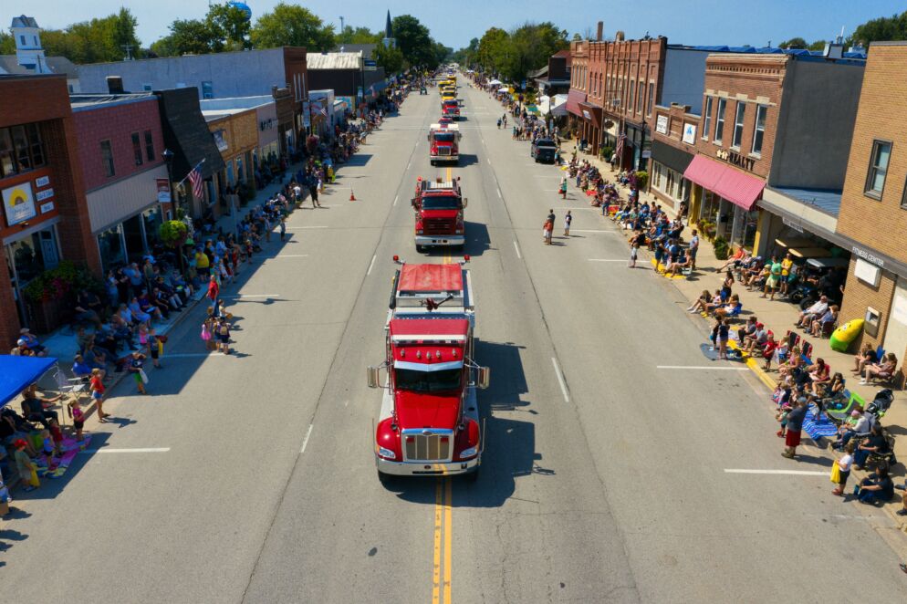 Trucks going down a street during a parade