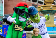 A boy poses with pickle mascots at The Big Dill Festival