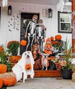 A family with two dogs all dressed up in Halloween costumes