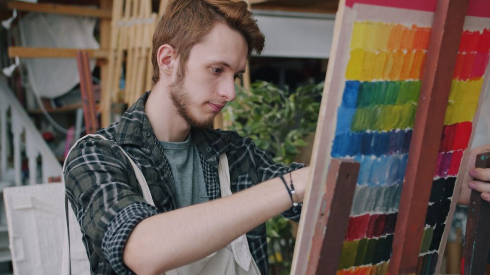 An artist working on a painting in a studio